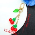 Detail shot of cute cherry resin keychain with size measurements 9.5cm in length - Transparent Red Leaf Cherry