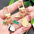 Cute enamel panda keychain with bamboo leaf charms in a gold finish with dimensions - Panda Turning Head Style (ER1130)