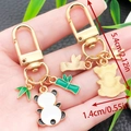 Cute panda charm gold keychain with green bamboo leaves, dimensions 5.4cm x 1.4cm - Standing Panda Style (ER1131)