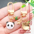 Cute panda charm keychain with bamboo leaf pendant in polished gold finish - Panda Head Style (ER1174)