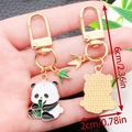 Cute panda metal keychain with green bamboo leaf charm and golden finish variant - Panda Holding Bamboo Style (ER1175)