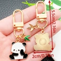 Cute golden panda metal keychain with green bamboo leaf pendant and enamel finish - Dazed Panda Style (ER1177)
