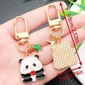 Cute panda metal keychain with red heart and bamboo leaf on dark textured background - Panda Eating Apple Style (ER1180)