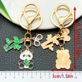 Cute panda metal keychain with bamboo charm in gold finish and green enamel accents - Bamboo Shoot Panda Style (ER1209)