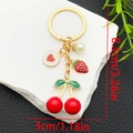 Detalle macro de llaveros de cereza y fresa con dimensiones y anillo dorado - Estilo Perla Fresa Cereza Roja (ER1628)
