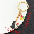 Detail van zwarte kat sleutelhanger met kleurrijke ballonnen en afmetingen 8,2cm x 3cm - Zwarte Kat Ballon