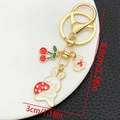 Detail view of rabbit keychain with red cherry charms and specific size measurements - White Enamel Mushroom Rabbit Cherry (ER1721)