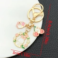 Detail view of cartoon rabbit wreath and milk box keychain with size measurements - White Drip Oil Cherry Milk Flower Rabbit (ER1729)