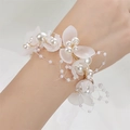 Close-up of a bridal wrist flower featuring white frosted petals and elegant pearls - SH White (Wrist Flower)
