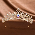 Detail of a luxurious golden crown featuring colorful rhinestones on a silk background - Gold Rainbow Diamond