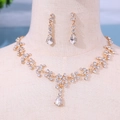 Elegantes goldenes Brautschmuck-Set mit Wassertropfen-Kristallen auf einem Display - Gold