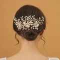 Elegant gold bridal hair comb with pearls and rhinestones on a low bun hairstyle - Gold