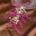 Detailed close-up of golden leaf bridal hairpiece with rose red rhinestones and pearls - Rose Red