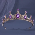 Macro-detail van de gouden tiara met paarse edelstenen en fonkelende strassteentjes - Goud Paars