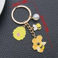 Bee keychain with yellow honeycomb heart charm and pearl on black leather background - Pearl Bee Honeycomb (ER1738)