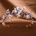 Close-up of golden bridal tiara with blue crystals, white petals and round pearls - Sapphire Blue