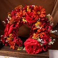 Detailaufnahme von handgefertigtem rotem Blumenkranz mit orangefarbenen Gänseblümchen - Stil 2