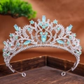 Detail of baroque silver crown with blue teardrop rhinestones on dark wooden base - Silver Green Opal