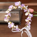 Close-up of Bohemian floral headband with purple flowers, shells, and white pearls - Purple