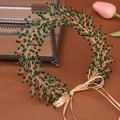 Detailopname van de handgemaakte haarband met groene kristallen kralen en gouden vlechtdraad - Groen