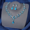 Silver bridal jewelry set with sea blue teardrop gemstones on a display stand - Silver Lake Blue