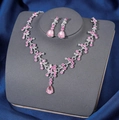 Elegant silver necklace and earrings set with pink pear-cut crystals on dark display - Silver Pink