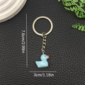 Detail showing a light blue resin duck keychain with silver metal ring and chain - Lake Blue (LS47)