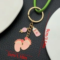 Roze babyvoetjes en zuigfles sleutelhanger met gouden plating op zwart leer - Roze Lolly Babyfles Voetjes Ketting (ER1516)
