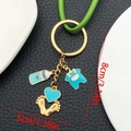 Porte-clés biberon bleu et body avec pendentif cœur doré et dimensions - Émail Bleu Vêtements Coeur Biberon Empreinte (ER1520)