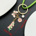Portachiavi con farfalla rosa e girasole con cinturino in pelle verde e finiture oro - Stile Farfalla Giglio Rosa (ER1542)