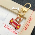 Close-up of Corgi driving red car enamel keychain with bone pendant and gold lobster clasp - Yellow And White Driving Puppy Style (LS362)