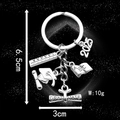 Silver 2025 graduation keychain featuring cap, scroll, and textbook charms for gift - 2025 Graduation Cap (LS65)