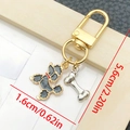 Llavero dorado con dije de perro teddy de esmalte gris y hueso plateado con cierre en D - Caniche Negro (LS346)