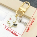 Cartoon hond en bot sleutelhanger in wit emaille en goud metaal met afmetingen - Witte Kwispelende Hond (LS351)