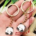 Golden panda keychain with black and white enamel finish measuring 7.7cm by 3cm - Drip Oil White Chinese Style Victory Sign Panda Style (ER1040)