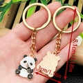 Cute panda enamel keychain in gold metal finish with 8.1cm total length on a hand - Panda Chewing Bamboo Style (ER1027)
