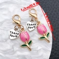 Close-up of pink enamel tulip heart charm with Thank You tag and golden lobster clasp - Rose Pink Tulip (ER2083)