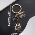 Enamel alloy keychain with butterfly and mushroom pendants in black and gold finish - Butterfly And Flower Style (ER693) / Black