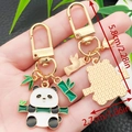 Cute cartoon panda keychain with green bamboo detail in golden finish metal - Panda on Horizontal Bamboo (ER1122)