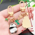 Simpatico portachiavi panda e bambù in smalto dorato con lunghezza totale di 6,2 cm - Panda che Abbraccia un Tronco (ER1125)