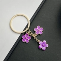 Eleganter violetter Emaille-Kirschblüten Schlüsselanhänger mit drei Blumen in Gold - Lila