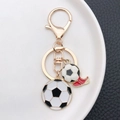 Llavero de fútbol dorado con balón esmaltado y bota roja para mochilas deportivas - Estilo Zapatos de Fútbol