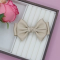 Eleganter champagnerfarbener Seidenhaarschleife-Clip mit zweischichtigem Design auf Rosa - Kamel