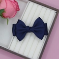 Detail of dark blue satin bow hair clip on a white jewelry tray with pink rose background - Navy Blue