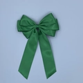 Detail view of smooth green satin bow hairclip with long ribbon tails and elegant silk texture - Green