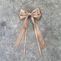 Détail d'une pince à cheveux avec long ruban en satin bronze doré sur pierre naturelle - Café Clair