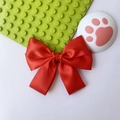 Close-up of a large red satin bow clip with a smooth glossy finish and elegant texture - Red