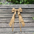 Elegant bronze satin bow hair clip with long ribbons displayed on a wooden bench - Light Coffee