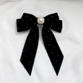 Dettaglio del fermaglio a fiocco in velluto nero con perla quadrata e strass luminosi - Nero
