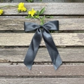 Eleganter dunkelgrauer Satin-Schleifen-Haarclip mit langen Bändern auf einer Holzbank - Schwarz